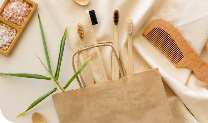 Sustainable bamboo products including toothbrushes, combs, and cotton buds on natural background